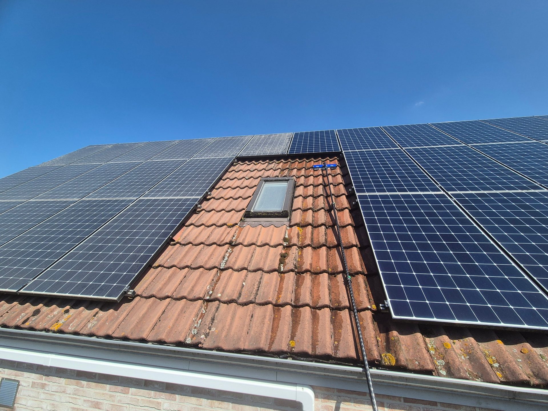 Panneaux solaires en cours de nettoyage à l'eau pure, moitié nettoyée, Enghien